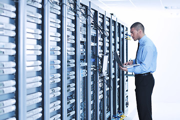 Image showing businessman with laptop in network server room