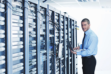 Image showing businessman with laptop in network server room