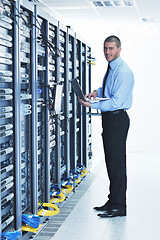 Image showing businessman with laptop in network server room