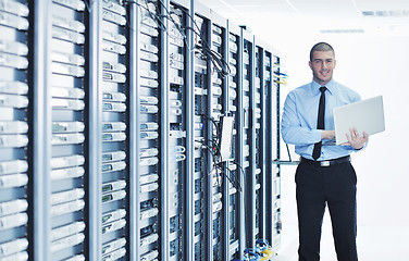 Image showing businessman with laptop in network server room