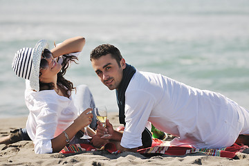 Image showing young couple enjoying  picnic on the beach