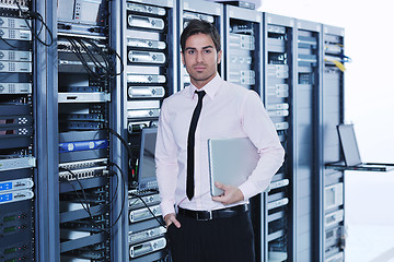 Image showing businessman with laptop in network server room