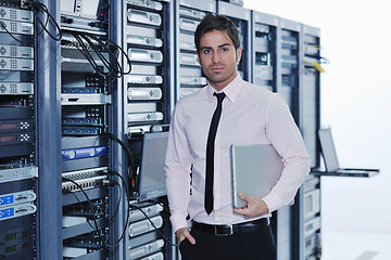 Image showing businessman with laptop in network server room