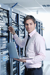 Image showing businessman with laptop in network server room