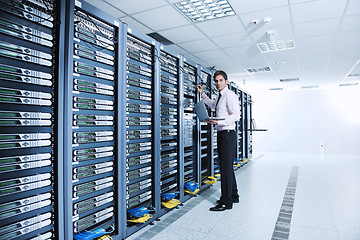 Image showing businessman with laptop in network server room