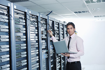 Image showing businessman with laptop in network server room