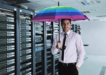 Image showing businessman hold umbrella in server room