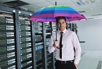 Image showing businessman hold umbrella in server room