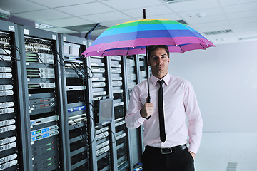 Image showing businessman hold umbrella in server room