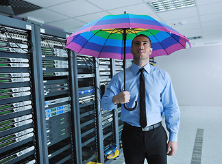 Image showing businessman hold umbrella in server room