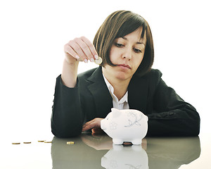 Image showing business woman putting coins money in piggy bank