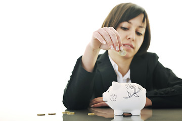 Image showing business woman putting coins money in piggy bank