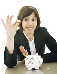 Image showing business woman putting coins money in piggy bank