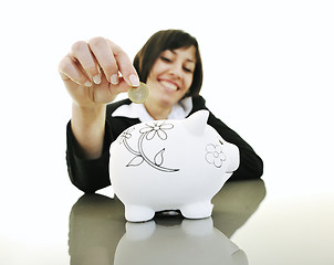 Image showing business woman putting coins money in piggy bank