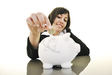 Image showing business woman putting coins money in piggy bank