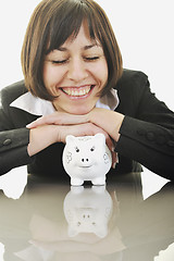 Image showing business woman putting coins money in piggy bank