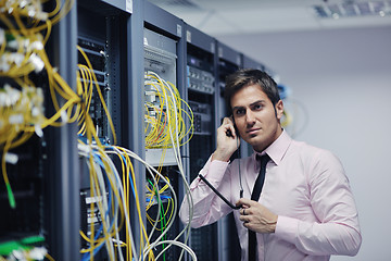 Image showing it engeneer talking by phone at network room