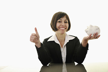 Image showing business woman putting coins money in piggy bank