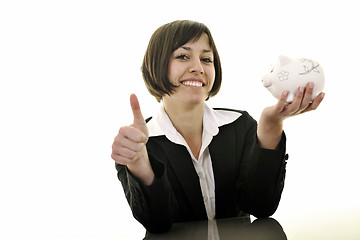 Image showing business woman putting coins money in piggy bank