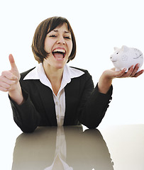 Image showing business woman putting coins money in piggy bank