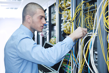 Image showing businessman with laptop in network server room