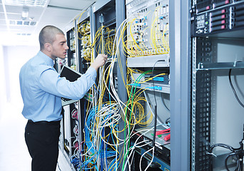 Image showing businessman with laptop in network server room