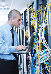 Image showing businessman with laptop in network server room