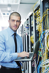 Image showing businessman with laptop in network server room