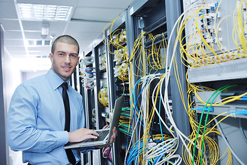 Image showing businessman with laptop in network server room