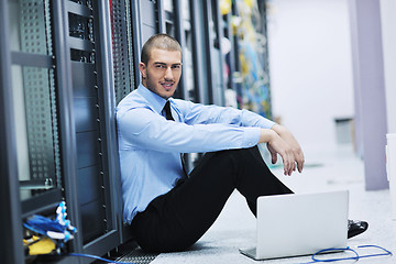 Image showing businessman with laptop in network server room