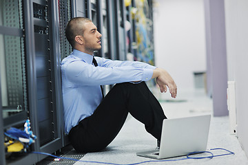 Image showing businessman with laptop in network server room