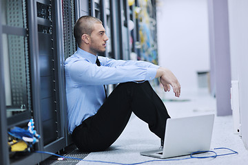 Image showing businessman with laptop in network server room