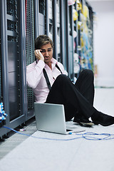 Image showing businessman with laptop in network server room