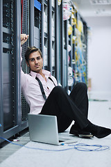 Image showing businessman with laptop in network server room