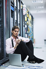 Image showing businessman with laptop in network server room