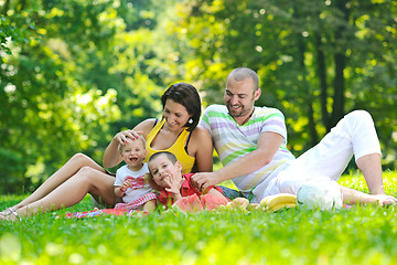 Image showing happy young couple with their children have fun at park