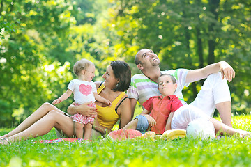 Image showing happy young couple with their children have fun at park