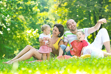 Image showing happy young couple with their children have fun at park