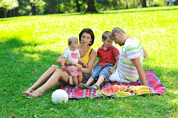 Image showing happy young couple with their children have fun at park