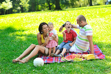 Image showing happy young couple with their children have fun at park