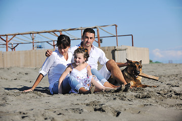 Image showing happy family playing with dog on beach