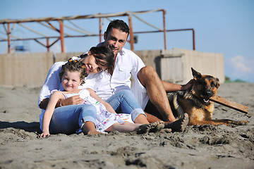 Image showing happy family playing with dog on beach