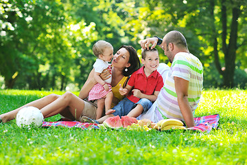 Image showing happy young couple with their children have fun at park