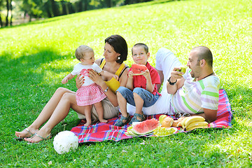 Image showing happy young couple with their children have fun at park