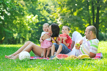 Image showing happy young couple with their children have fun at park