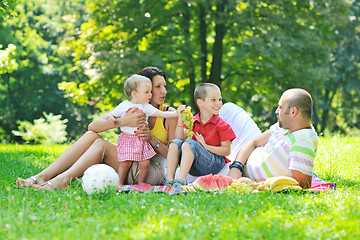 Image showing happy young couple with their children have fun at park