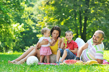 Image showing happy young couple with their children have fun at park