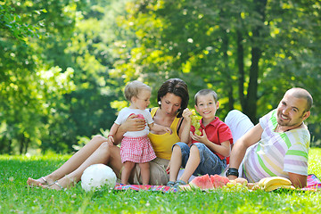 Image showing happy young couple with their children have fun at park