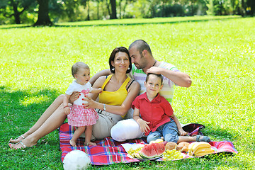 Image showing happy young couple with their children have fun at park