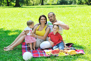 Image showing happy young couple with their children have fun at park